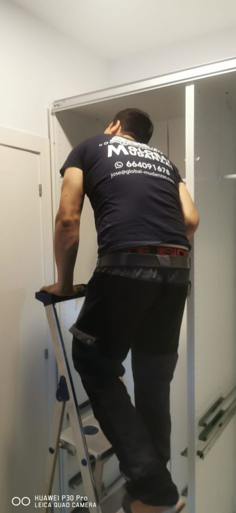 Operario de Global Mudanzas ajustando un armario durante un trabajo de montaje